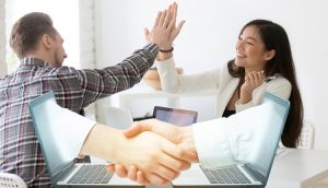 Young asian and caucasian partners giving high five at workplace, diverse motivated colleagues celebrate goal achievement
