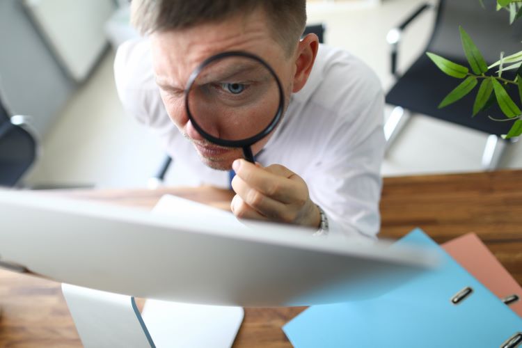 man holding a magnifying glass close to his eye