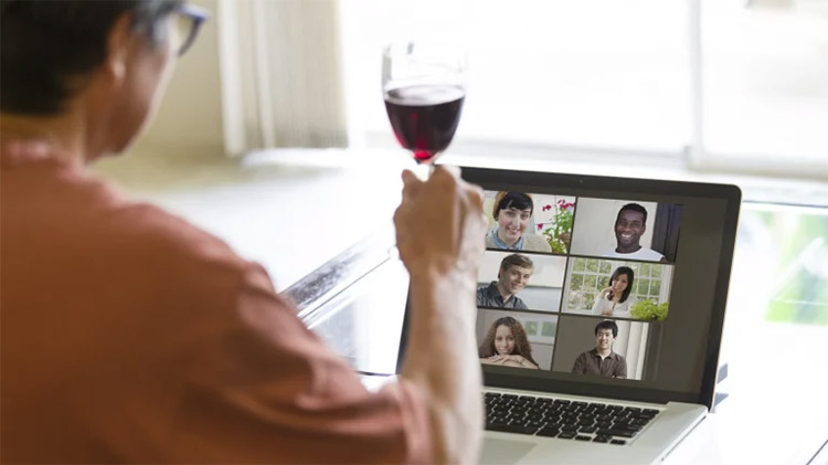 female employer raising glass during a video call